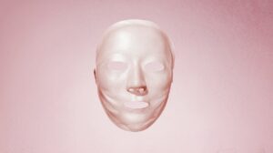 Elegant white Korean sheet mask floating against pink background.