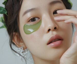 Close up of a woman with a green eye mask.